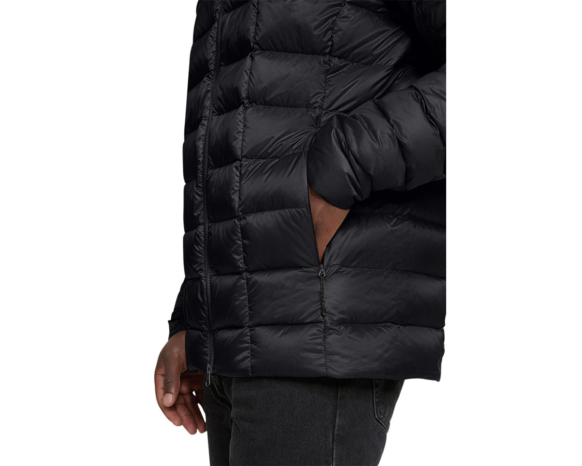 Black puffer jacket worn by a person on a white background