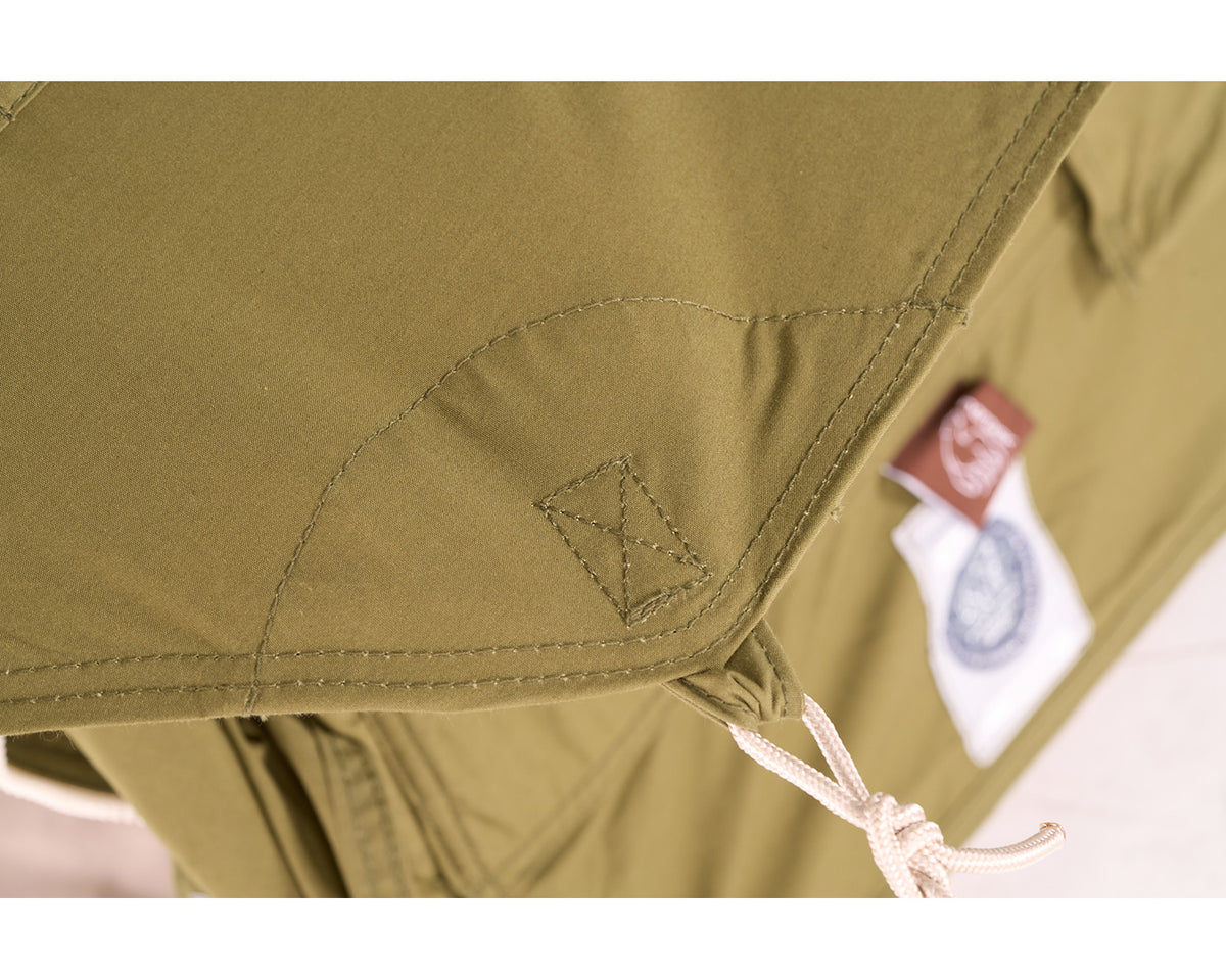 Close-up of a green jacket with a brand label on a white background