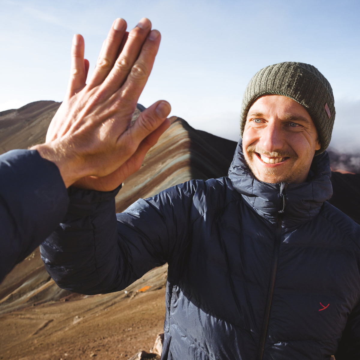 Lehrke twins giving a high five while hiking the Rainbow Mountain in Peru.