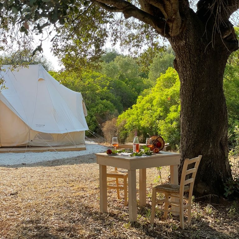 Luxury glamping tent and outdoor dining table at Nordisk Village Puglia in Italy.