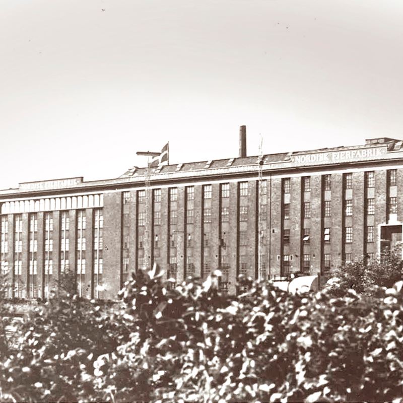 Historic Nordisk Fjerfabrik factory building with the company name on the facade from 1908.