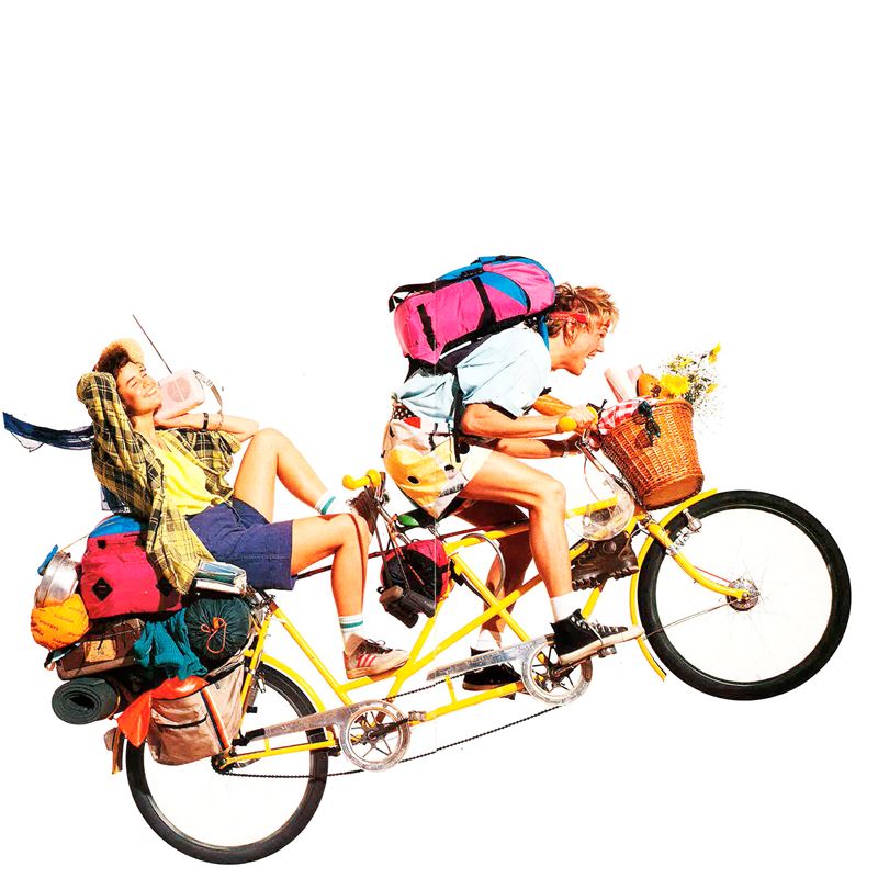 Vintage retro outdoor gear and colorful backpacks on a tandem bicycle from the 1974 Caravan catalogue.