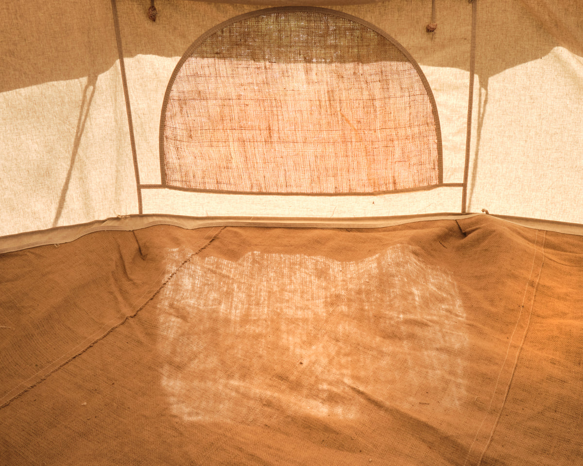 Close-up of a beige tent interior with a mesh window.