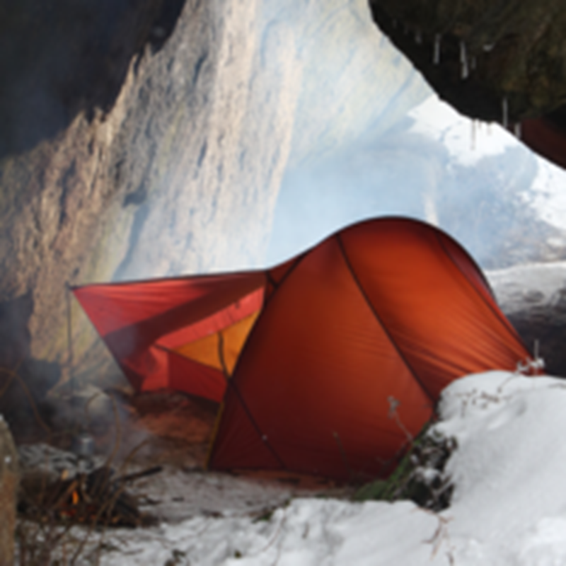 Red Nordisk Telemark 1 ULW tent pitched in a snowy cave during winter.