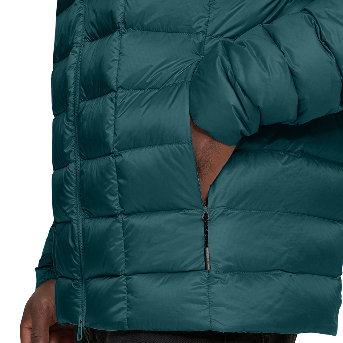 Close-up of a dark teal puffer jacket with horizontal quilting, a front zipper, and a side pocket showing a hand inside, on a white background.