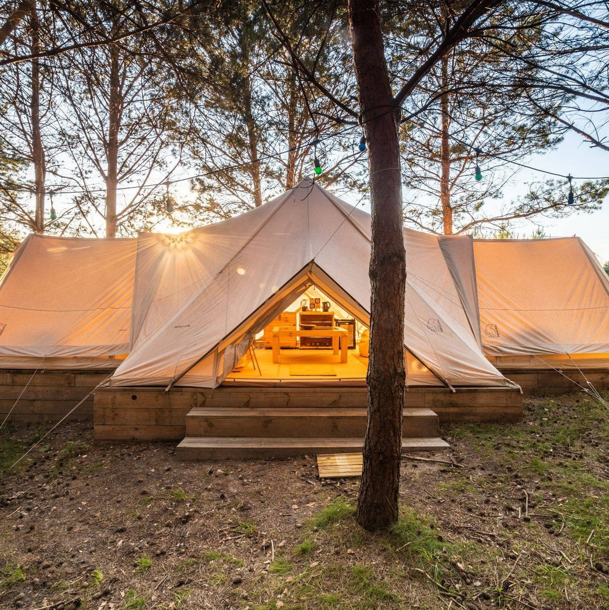 Luxury glamping tent at Nordisk Village Jura in Poland, nestled in a scenic forest setting.