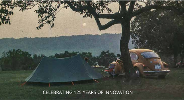 Vintage camping scene with a green tent and classic car celebrating 125 years of Nordisk.