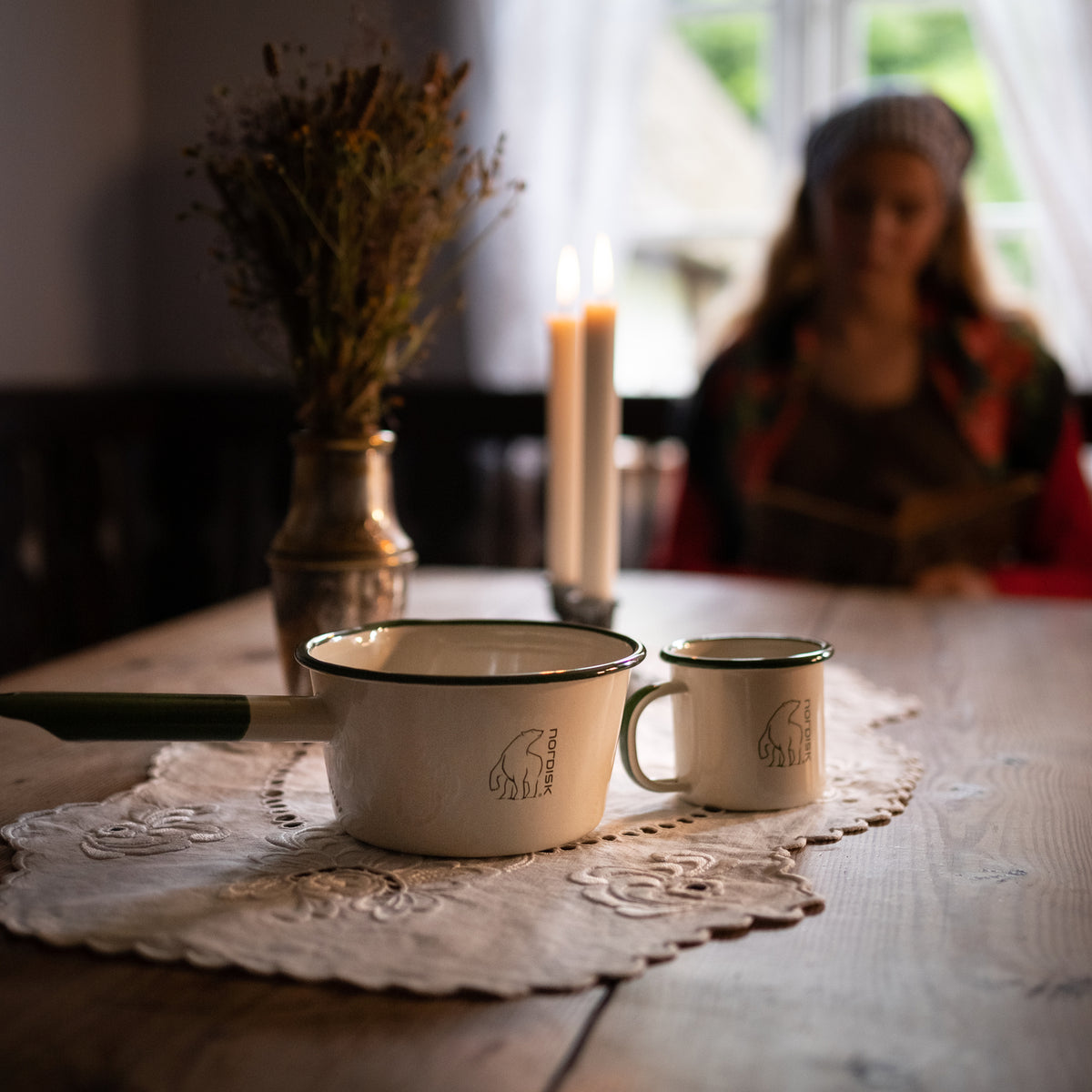 Madam Blå enamel saucepan and mug on a table, showcasing the Danish Hygge culture.