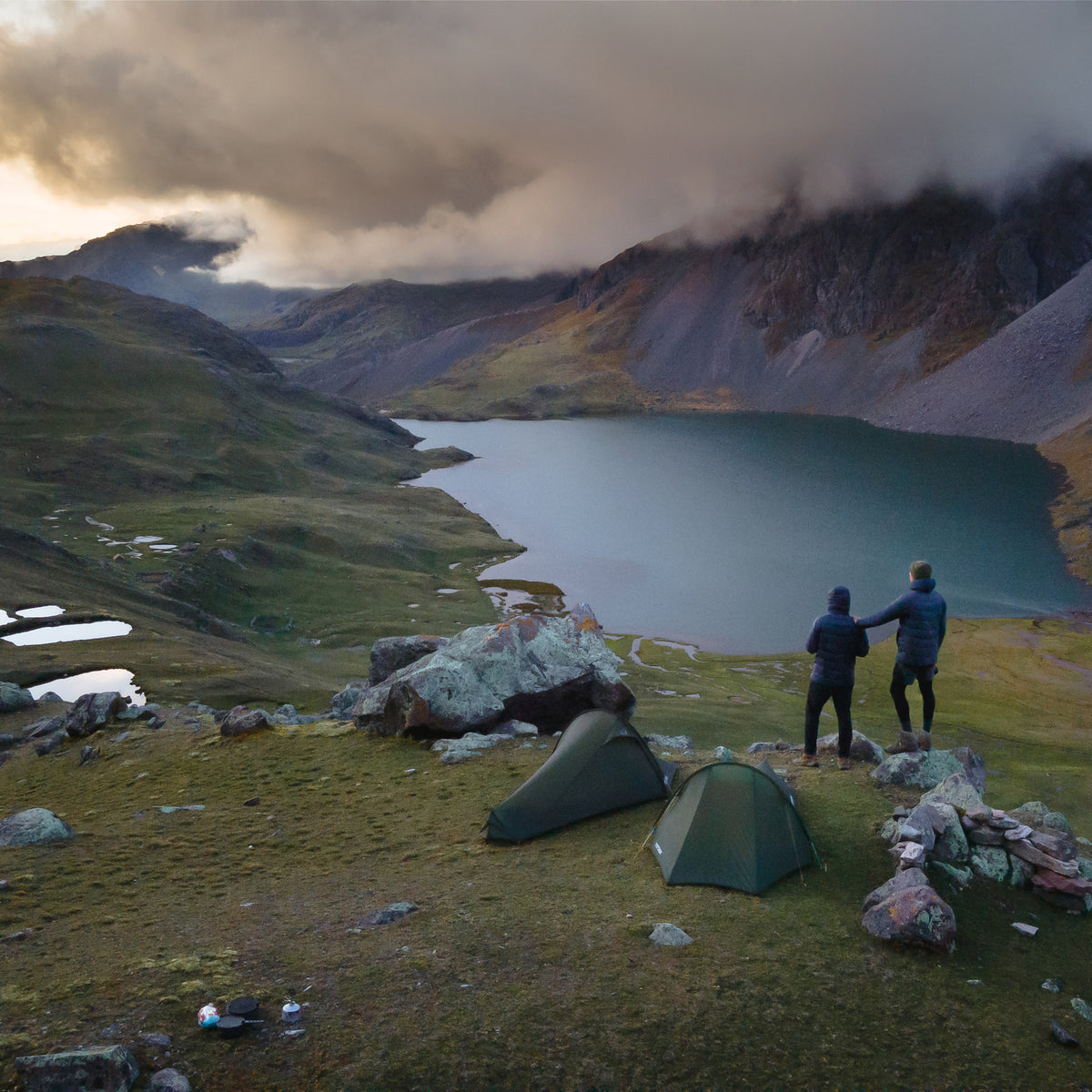 Two hikers overlooking a mountain lake while wild camping in Peru with Nordisk tents.