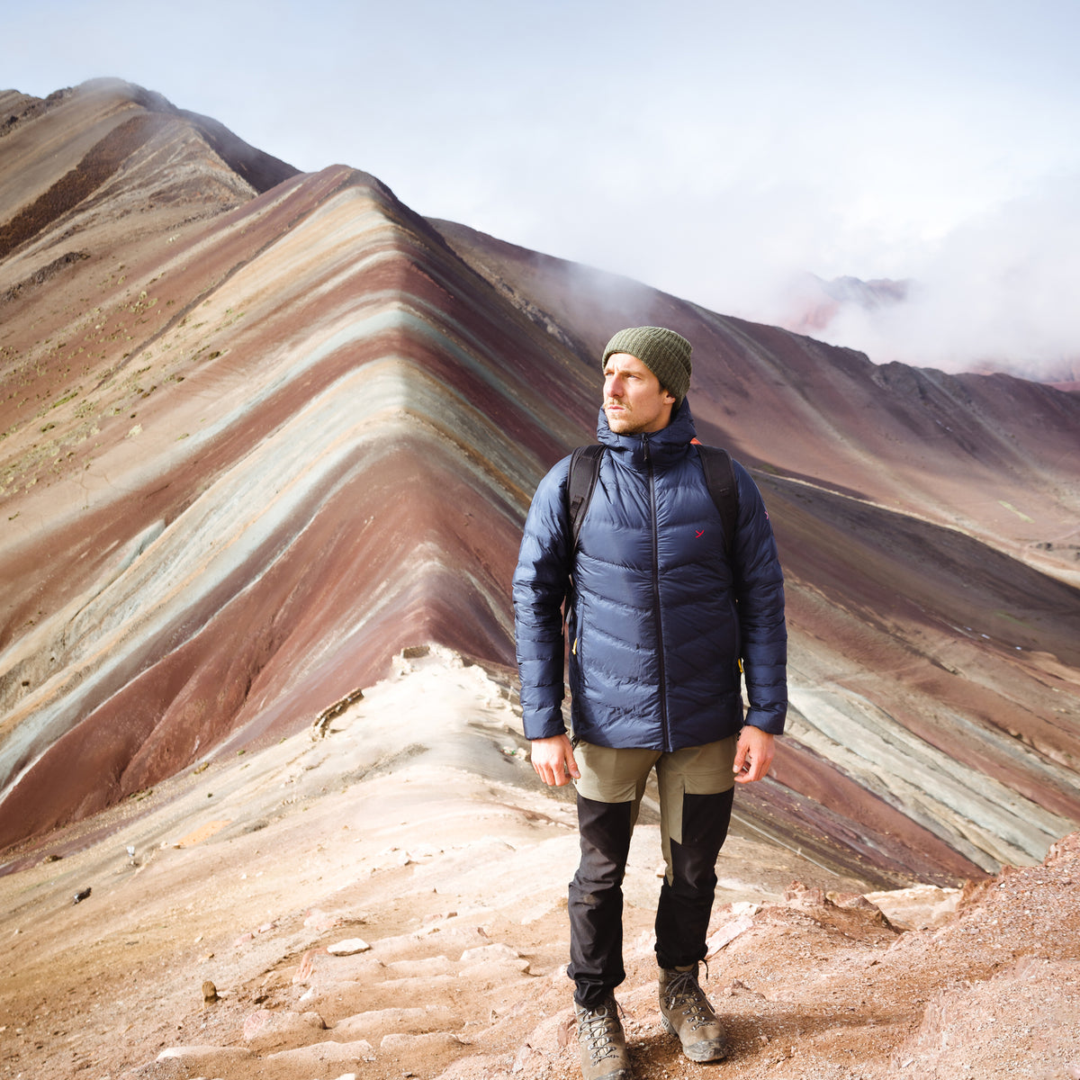 Max Lehrke wearing outdoor gear while hiking at Rainbow Mountain in Peru.